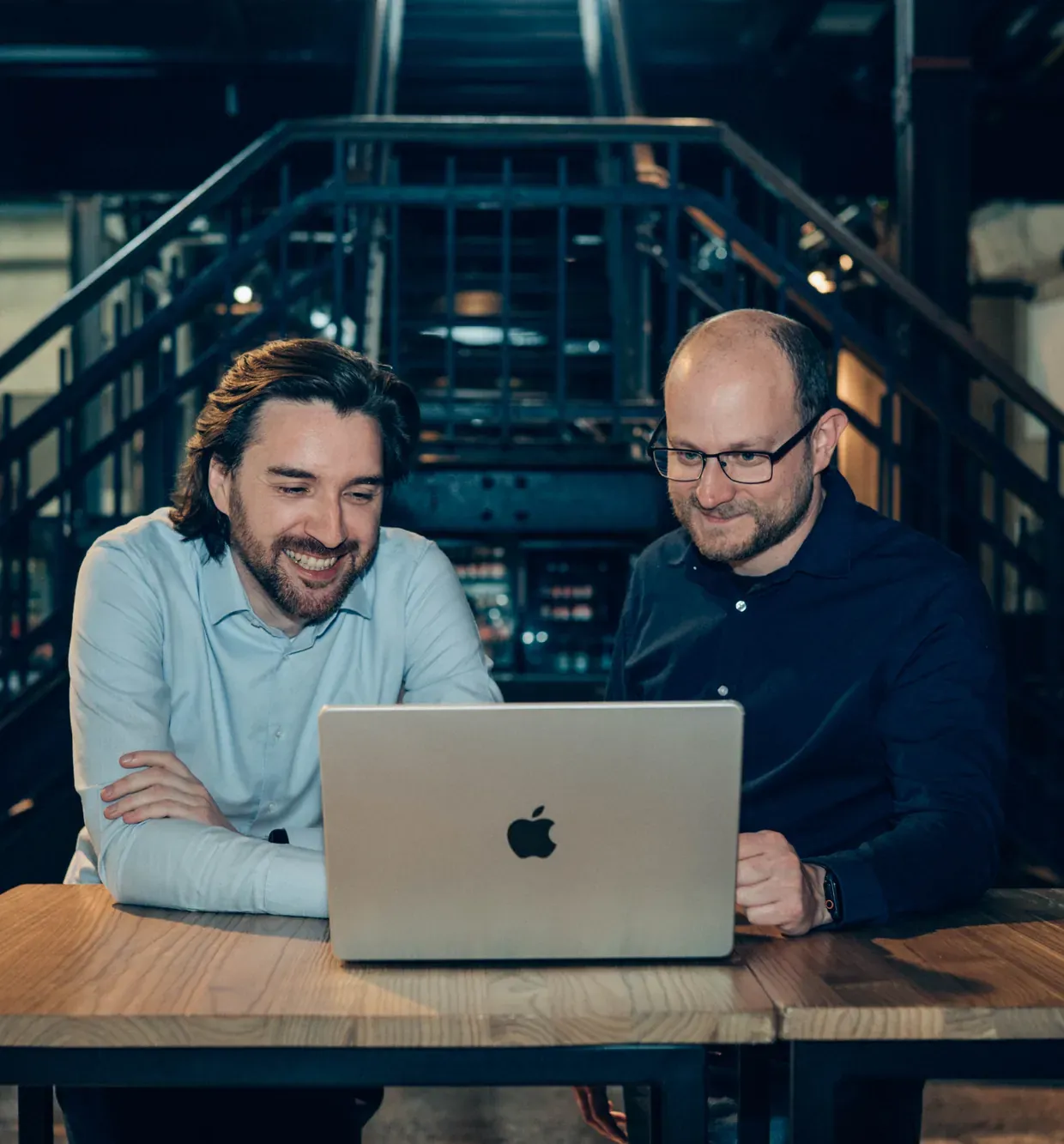 Raf and Gunther at a work table with a MacBook between them